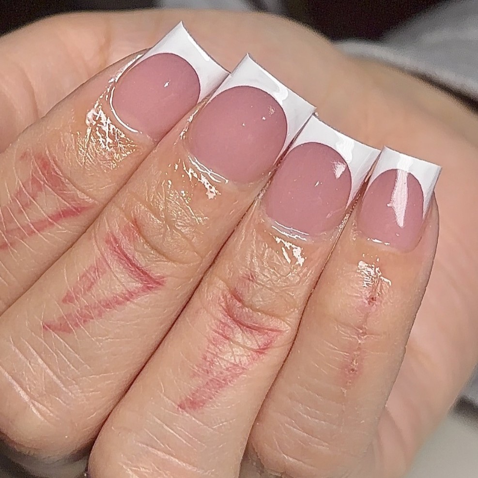 Mini square Gel-X nails with a sheer pink nude base and classic white French tips by n4ilsbybellaa.