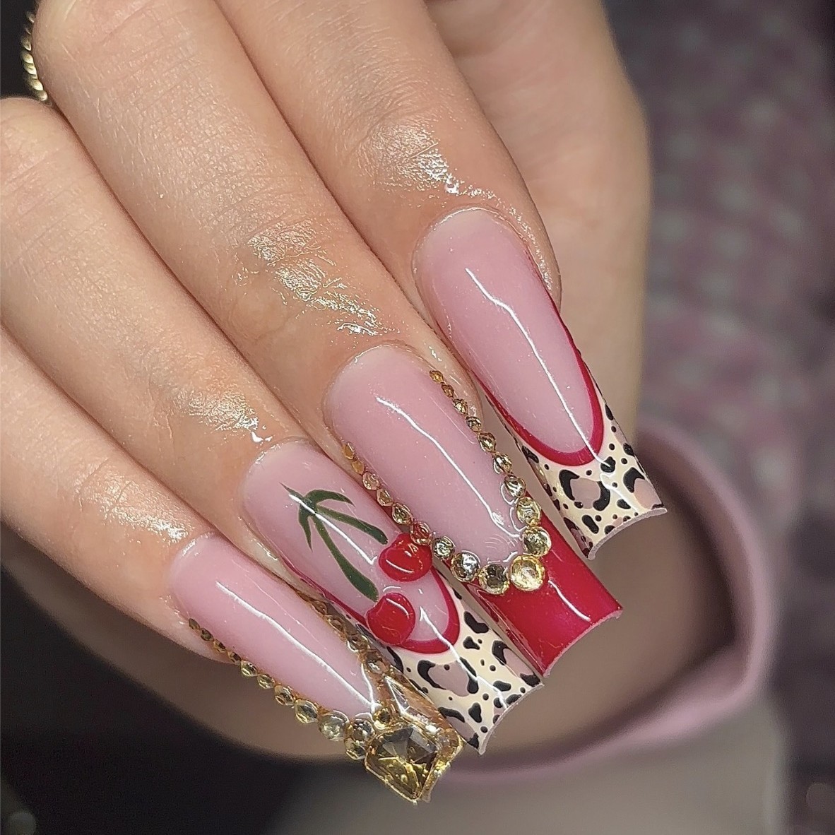 Extra-long square Gel-X nails featuring red chrome French tips, cherry nail art, rhinestone details, and animal-print accents by n4ilsbybellaa